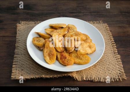 Leckere, frittierte Bananenscheiben auf einem Holztisch Stockfoto