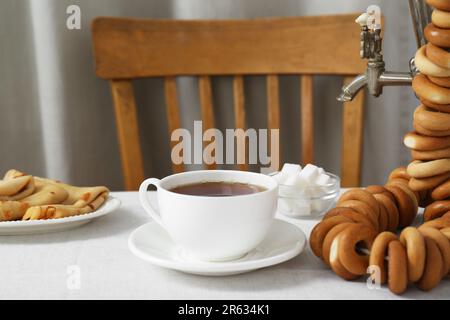 Klassischer Samovar, eine Tasse heißes Getränk und Snacks werden auf dem Tisch serviert. Traditionelle russische Teezeremonie Stockfoto