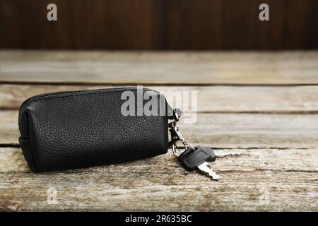 Ledertasche mit Schlüsseln auf altem Holztisch, Nahaufnahme. Platz für Text Stockfoto