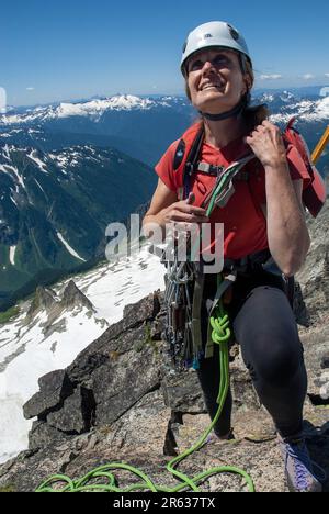 Weibliche Klettererin auf dem Verbotenen Gipfel. North Cascades, Washington. USA Stockfoto