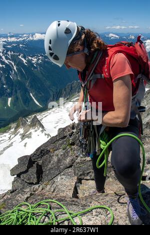 Weibliche Klettererin auf dem Verbotenen Gipfel. North Cascades, Washington. USA Stockfoto