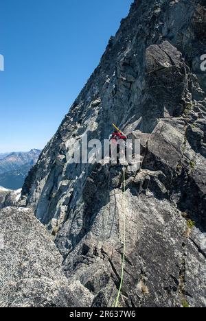 Weibliche Klettererin auf dem Verbotenen Gipfel. North Cascades, Washington. USA Stockfoto