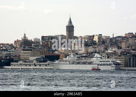 Der Galataturm über einem Kreuzfahrtschiff in Karakoy und Beyoglu entlang der Straße des Bosporus auf der europäischen Seite von Istanbul, Türkei/Turkiye. Stockfoto