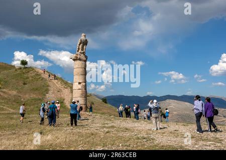 Touristen bewundern eine Steinadlerstatue auf der südlichen Säule an der antiken Stätte Karakus Tumulus in Cukurtas in Turkiye. Stockfoto