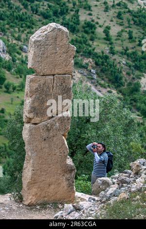 Ein Mann fotografiert das Mithras Relief an den Ruinen von Arsameia (Arsameia auf den Nymphaios) in der Provinz Adiyaman im Südosten Turkiyes. Stockfoto