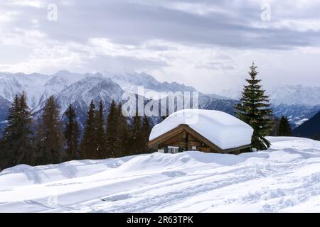 Alpenhütte versenkte sich im Winter in tiefem Schnee mit dickem Schnee auf dem Dach in den Schweizer Alpen Stockfoto