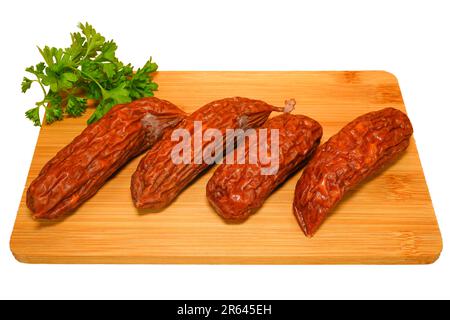 Geräucherte Würstchen auf Holzschneidplatte mit Petersilie. Fleischzusammensetzung. Stockfoto