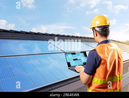 Ingenieure arbeiten mit Solarpaneelen auf dem Hausdach und erzeugen Strom für den Hausgebrauch Stockfoto