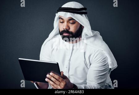 Auf der Suche nach Möglichkeiten, sein Geschäft zu verbessern. Studiofoto eines jungen Mannes in islamischer traditioneller Kleidung, der vor einem dunklen Hintergrund posiert. Stockfoto