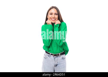 Junge, braunäugige, braunhaarige Frau in einer grünen Bluse freut sich und lächelt Stockfoto