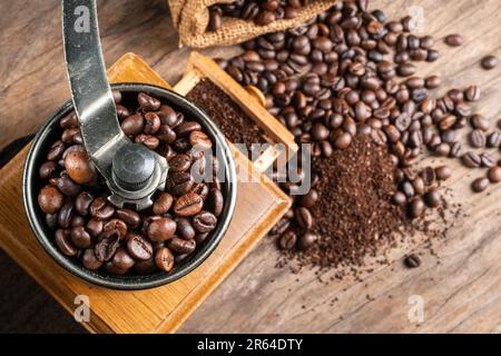 Vintage-Kaffeemühle. Alte handbetätigte Holz- und Metall-Kaffeemühle im Retro-Stil. Manuelle Kaffeemühle zum Mahlen von Kaffeebohnen. Weichzeichner. Stockfoto