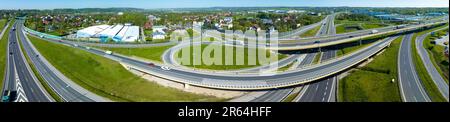 Krakau, Polen. Breites Panoramablick über die mehrstöckige Spaghetti-Kreuzung der Autobahn mit Rampen, Zufahrtsstraßen, Viadukten, Autos, Lastwagen und Verkehr Stockfoto