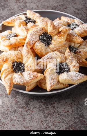 Joulutorttu Tahtitorttu finnische Pinwheel-förmige Weihnachtstörtchen in Nahaufnahme auf einem Teller auf einem Tisch. Vertikal Stockfoto