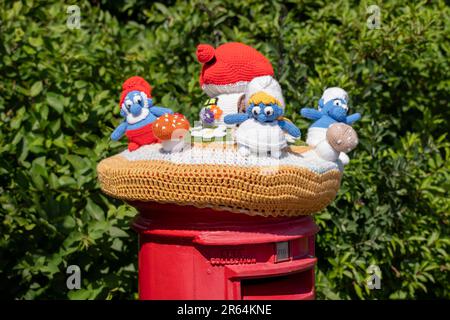 Häkelschlümpfe auf einem Briefkasten in Carisbrooke, Isle of Wight, England, Großbritannien. Stockfoto