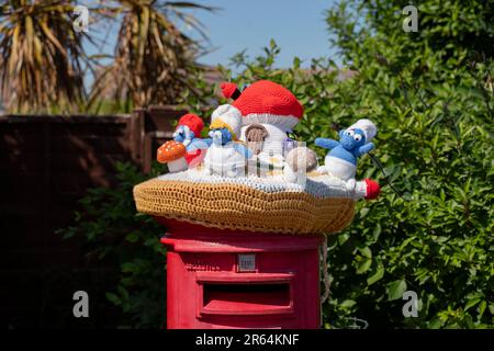 Häkelschlümpfe auf einem Briefkasten in Carisbrooke, Isle of Wight, England, Großbritannien. Stockfoto