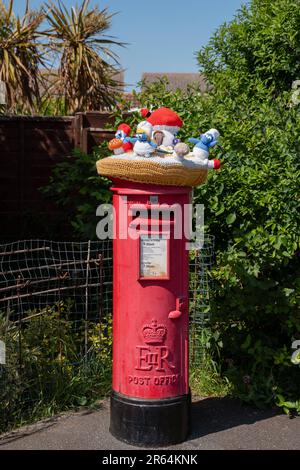 Häkelschlümpfe auf einem Briefkasten in Carisbrooke, Isle of Wight, England, Großbritannien. Stockfoto