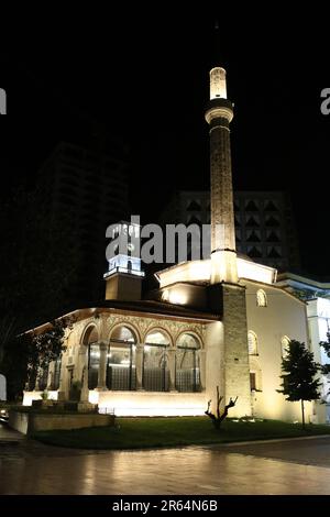 Die Hajji et'hem Bey Moschee ist eine Moschee in Tirana, Albanien. Die unter kommunistischer Herrschaft geschlossene Moschee wurde 1991 als Gotteshaus wiedereröffnet. Ohne Genehmigung der Behörden waren 10.000 Personen anwesend, und die Polizei hat sich nicht eingemischt. Fresken im Freien und im Säulenbereich stellen Bäume, Wasserfälle und Brücken dar. Auf der linken Seite befindet sich der Uhrenturm von Tirana, der 1822 in Tirana, Albanien, von et'hem bey Mollaj, einem Bejtexhinj-Dichter, erbaut wurde, der auch die et'hem Bey Moschee neben dem Uhrenturm fertigstellte. Stockfoto