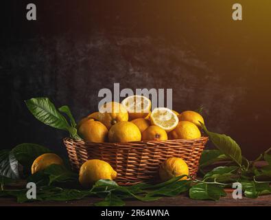 Frisches Bio-Zitronenobst mit Blättern im Korb auf einem Holztisch, Kopierbereich Stockfoto