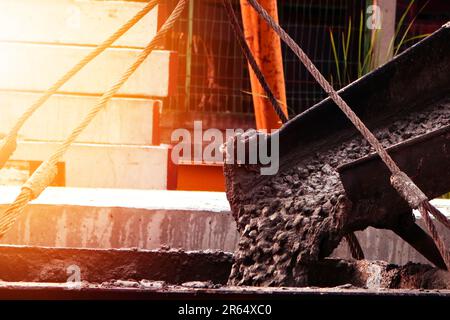 Mischer, der auf der Baustelle Zement oder Beton ausgießt Stockfoto