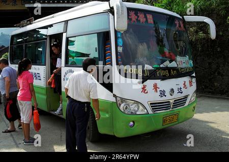 龙胜镇 (龙胜县) 中國 Longsheng, China; Passagiere steigen in einen kleinen chinesischen Bus; Passagiere steigen in einen kleinen chinesischen Bus; 中国の小型バスに乗車する乗客 Stockfoto
