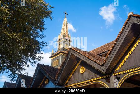 Der Turm erhebt sich über die berühmte hölzerne Kirche oder die katholische Kontum-Kathedrale in der Stadt Kontum im zentralen Hochland von Vietnam. Die Kirche Stockfoto