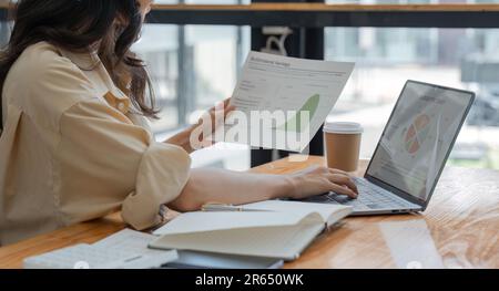 Wirtschaftsprüfer, der anhand von Diagrammen und Diagrammen Marktdaten, Bilanzen, Konten und Nettogewinne analysiert, um neue Umsätze zu planen Stockfoto