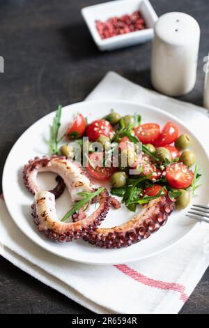 Salat mit Kraken, Tomaten, Oliven und Rucola. Frischer, gesunder Salat. Stockfoto