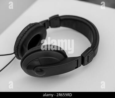 Schwarze kabellose Over-Ear-Kopfhörer auf hellem Holzhintergrund. Stockfoto