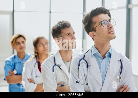 Erfolgreiches Ärzteteam schaut in die Kamera und lächelt im Stehen Stockfoto