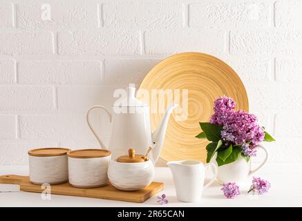 Moderner, stilvoller Küchenhintergrund in weißen Farbtönen mit umweltfreundlichen verschiedenen Utensilien und Utensilien vor dem Hintergrund einer weißen Backsteinwand Stockfoto