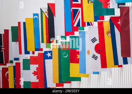 Hintergrund mit lebendigen Flaggen von Ländern aus der ganzen Welt, die an internationalen Konferenzen teilnehmen Stockfoto