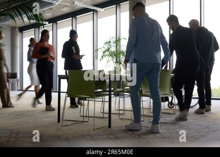 Eine vielfältige Gruppe von Geschäftsleuten versammelt sich an einem Tisch für Meetings, um Diskussionen, Zusammenarbeit und strategische Planung in einem zu führen Stockfoto
