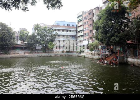 DHAKA, BANGLADESCH - JUNI 2: Am 2. Juni 2023 baden Menschen in einem Teich in Old Dhaka in Dhaka, Bangladesch. Dhaka ist eine Megacity und hat 10,2 Einwohner Stockfoto