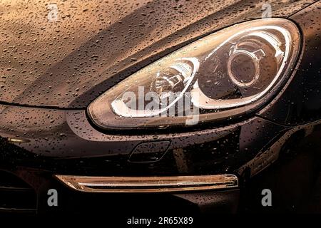 Eine beeindruckende Nahaufnahme des Frontscheinwerfers eines Luxusautos, der glänzt. Stockfoto