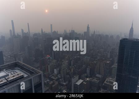 Manhattan, USA, 07/06/2023, Skyline von Manhattan verdeckt von Dunst von kanadischen Waldbränden, die eine besondere Atmosphäre vermitteln. Stockfoto