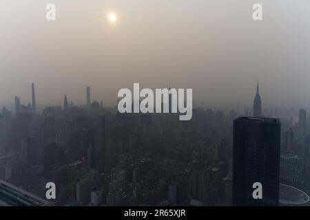 Manhattan, USA, 07/06/2023, Skyline von Manhattan verdeckt von Dunst von kanadischen Waldbränden, die eine besondere Atmosphäre vermitteln. Stockfoto