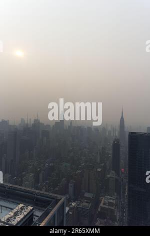 Manhattan, USA, 07/06/2023, Skyline von Manhattan verdeckt von Dunst von kanadischen Waldbränden, die eine besondere Atmosphäre vermitteln. Stockfoto