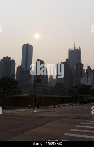 Manhattan, USA, 07/06/2023, Skyline von Manhattan verdeckt von Dunst von kanadischen Waldbränden, die eine besondere Atmosphäre vermitteln. Stockfoto