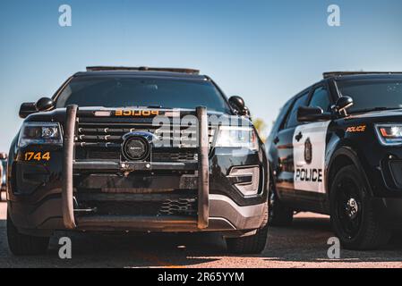 Der Frontgrill und das Seitenprofil der Ford Police Cruisers, Ein klarer blauer Himmel im Hintergrund Stockfoto