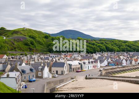 6. Juni 2023 Cullen, Moray, Schottland. Dies ist der Blick über den Hafen, Fischerstädte Cottages, Castle Hill und den bin of Cullen an einem sonnigen Nachmittag Stockfoto