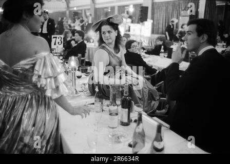 1980er-Mode. Die Ballkönigin in einem nackten, einSchulterkleid und einem übermäßig großen Schleifenkopfstück beim jährlichen Rose Ball im Grosvenor House Hotel. Mayfair, London, UK, ca. Mai 1982. HOMER SYKES Stockfoto