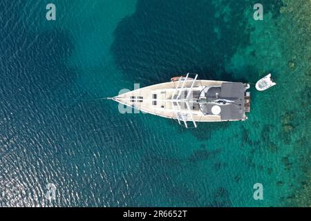 Luftaufnahme einer Segelyacht, die durch das schimmernde blaue Wasser der Adria fährt Stockfoto