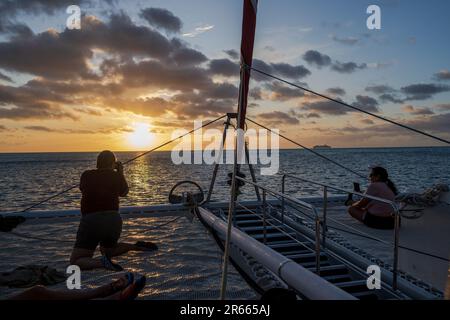 Bora Bora, Französisch-Polynesien--3. Februar 2023. Touristen auf einem Katamran für eine Bootstour bei Sonnenuntergang in den Gewässern von Bora Bora. Stockfoto