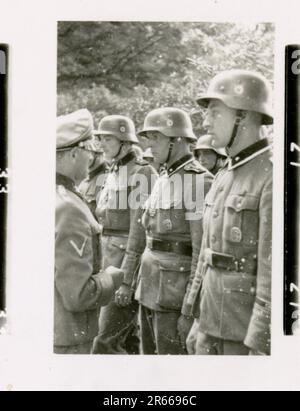 SS-Fotograf Bergmann, Johannes, Leibstandarte Adolf Hitler, Frankreich 1940 Bivouac und tägliche Feldaktivitäten; deutsche Gräber; mit Flüchtlingen trainieren; Infanterie marschieren; französische Truppen und Kriegsgefangene aufgeben; kleine und große Flugabwehreinheit; französischer Flugplatz mit Kampfflugzeugen besetzt; französisches Stabfahrzeug mit Papieren und Karten gefangen; Zeremonie mit Sepp Dietrich, Fotos von einzelnen Auszeichnern und Mitgliedern der Einheit, Aktivitäten nach dem Waffenstillstand, wie z. B. Fahrzeugwartung, Entspannung der Einheitenmitglieder, körperliches Training der Einheit und andere alltägliche Aufgaben, Landschaftsaufnahmen o Stockfoto