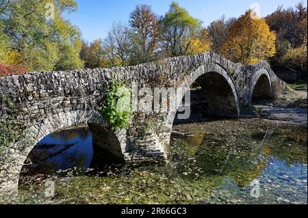 Blick auf die traditionelle Steinbrücke Mylos in Epirus, Griechenland im Herbst Stockfoto