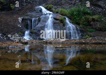 Ein wunderschöner Wasserfall inmitten von Felsen. Naturhintergrund. Stockfoto