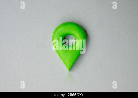 Grünes Positionssymbol eines Stifts auf blauem Hintergrund, 3D GPS-Stiftsymbol aus Plastik, Standortkonzept. Stockfoto