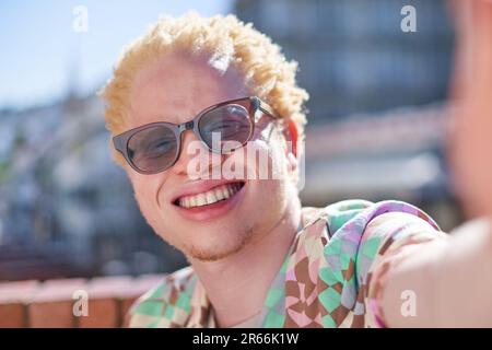 Nahaufnahme Selfie POV Portrait glücklicher junger Albino Mann lächelnd Stockfoto