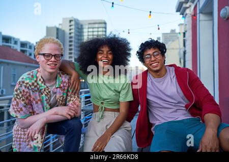 Porträt fröhliche junge Freunde auf dem Balkon des urbanen Apartments Stockfoto