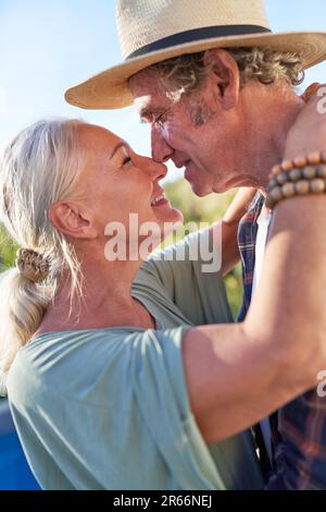 Ein glückliches, liebevolles Seniorenpaar, das sich umarmt und küsst Stockfoto